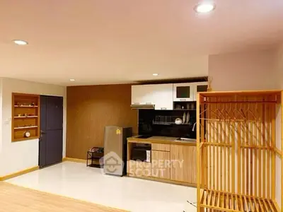 Modern kitchen with sleek appliances and stylish wooden accents in a cozy apartment setting.