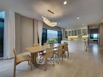 Elegant dining area with modern chandelier and open kitchen layout in a luxury home.