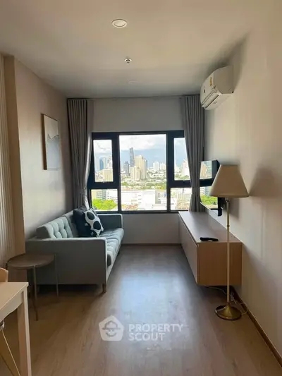 Modern living room with city view, featuring sleek furniture and large windows for natural light.
