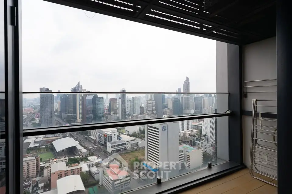 Stunning cityscape view from a high-rise balcony with modern railing and expansive skyline.