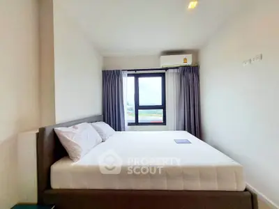 Modern bedroom with large window and air conditioning in a bright apartment.