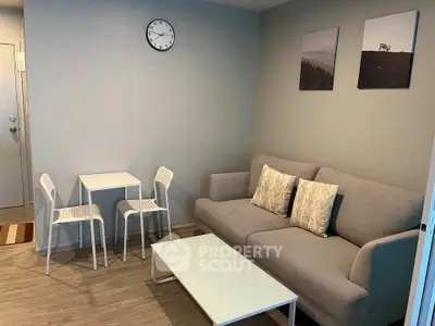 Cozy living room with modern decor, featuring a comfortable sofa and minimalist dining set.
