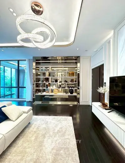 Luxurious living room with modern chandelier and elegant decor, featuring a large window with a scenic view.