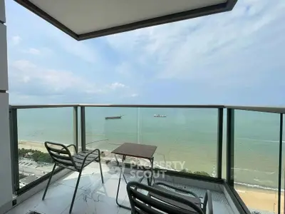 Stunning ocean view from a modern balcony with sleek glass railing and stylish seating.