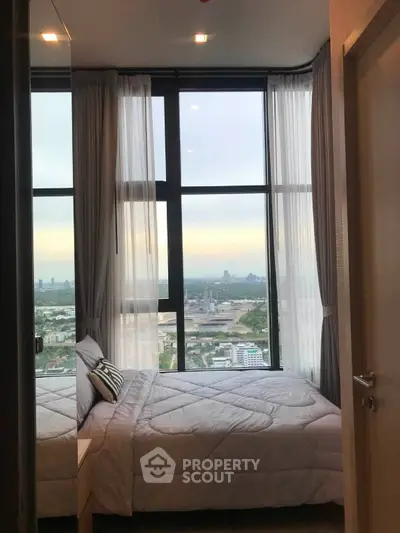 Stunning bedroom with panoramic city view and floor-to-ceiling windows in modern high-rise apartment.