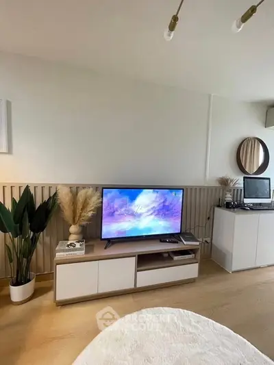 Modern living room with stylish decor and entertainment setup, featuring a sleek TV stand and elegant lighting.