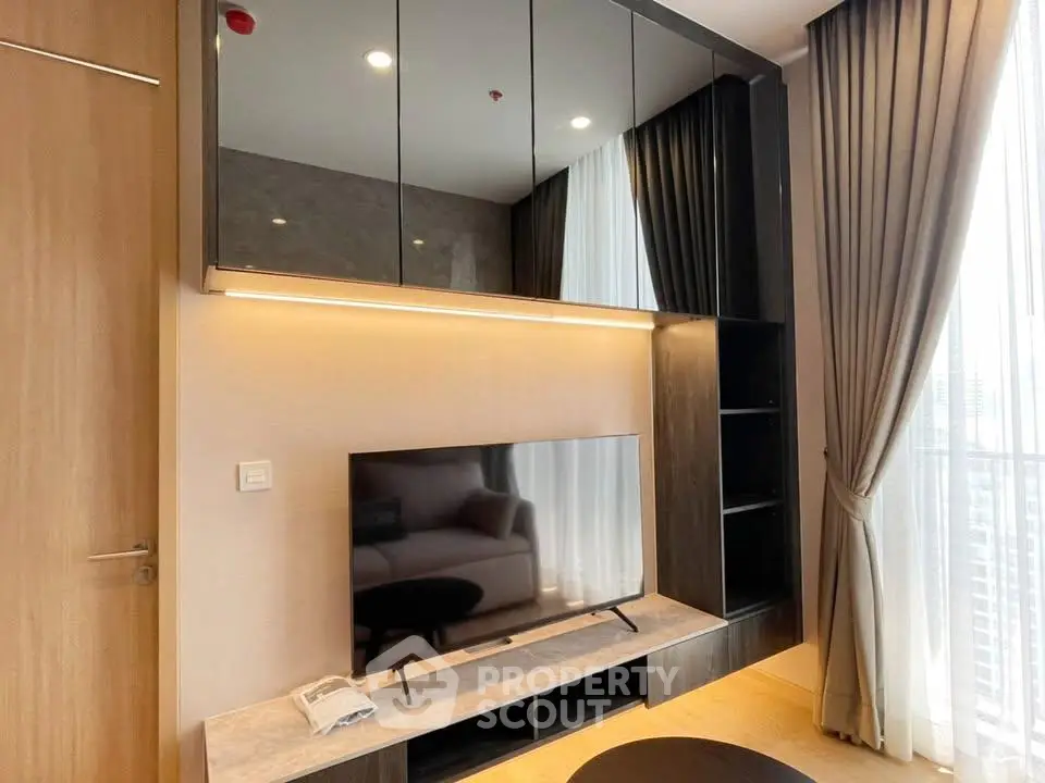 Modern living room with sleek TV unit and floor-to-ceiling curtains