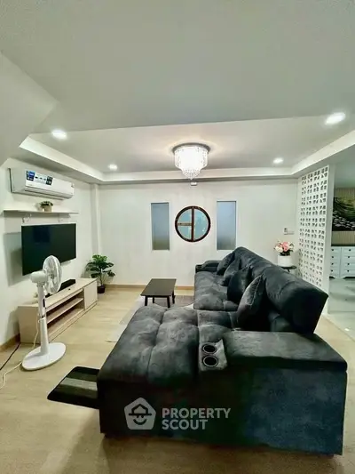 Spacious living room with modern decor and plush seating, perfect for relaxation and entertainment.