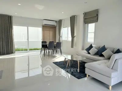 Spacious modern living room with sleek furniture and large windows.