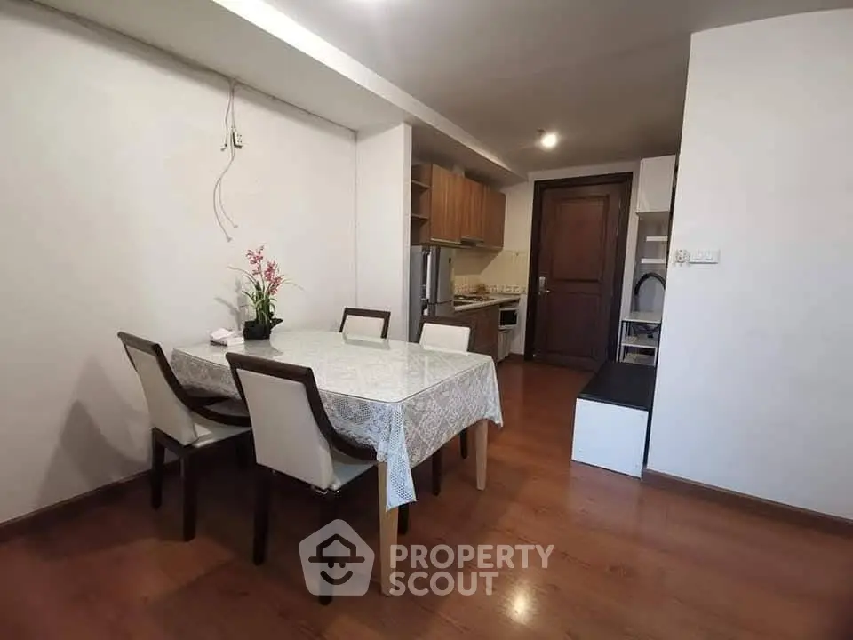 Cozy dining area with wooden flooring and modern kitchen setup