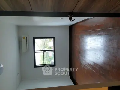 Spacious empty room with wooden floors and large window