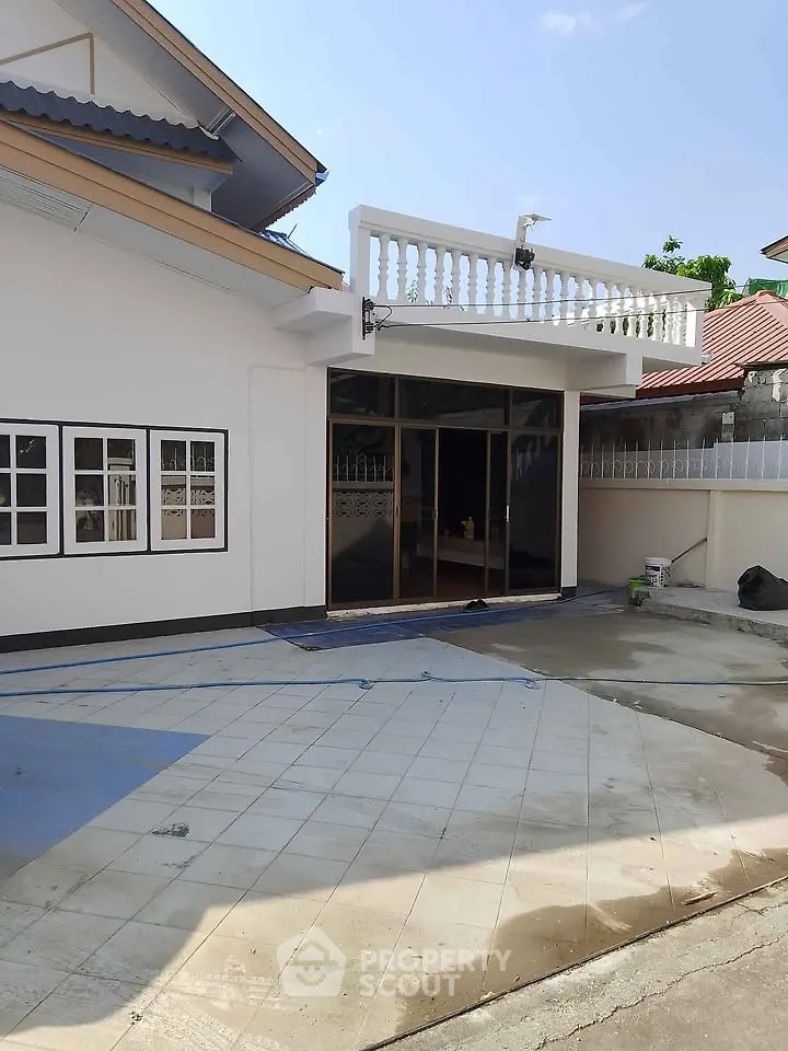Charming single-story home with spacious tiled patio and modern glass doors, perfect for outdoor gatherings.