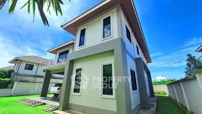 Modern two-story house with spacious garden and clear blue sky