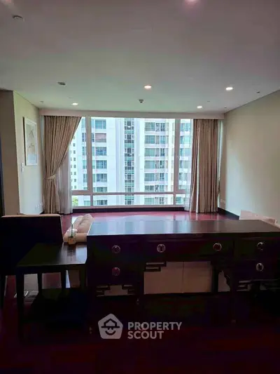 Spacious living room with large windows offering stunning city views in a modern apartment.