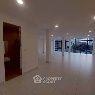 Spacious open-plan living area with large windows and city view.