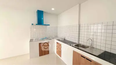 Modern kitchen with sleek design, featuring white tiles and wooden cabinets, perfect for culinary enthusiasts.