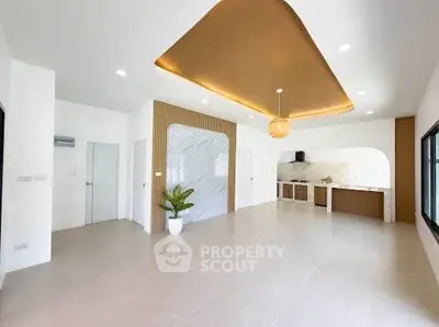 Spacious modern living room with open kitchen and elegant ceiling design