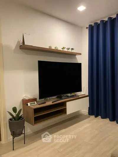 Modern living room with wall-mounted TV and elegant blue curtains