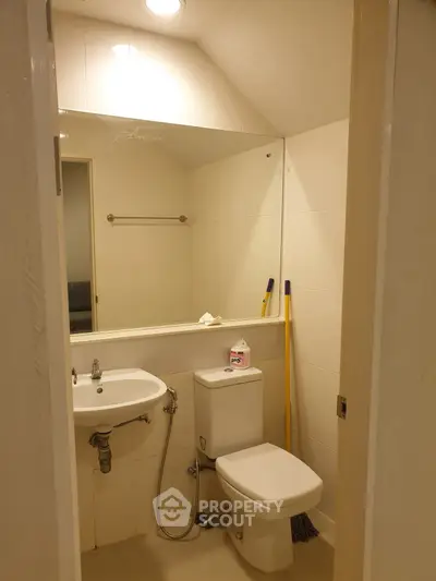 Compact bathroom with modern fixtures and large mirror