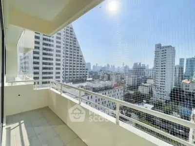 Spacious balcony with stunning city skyline view in modern high-rise building.