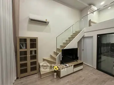 Modern living room with stylish staircase and sleek TV setup