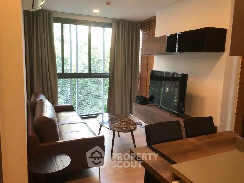 Modern living room with large window and stylish furniture in a cozy apartment.