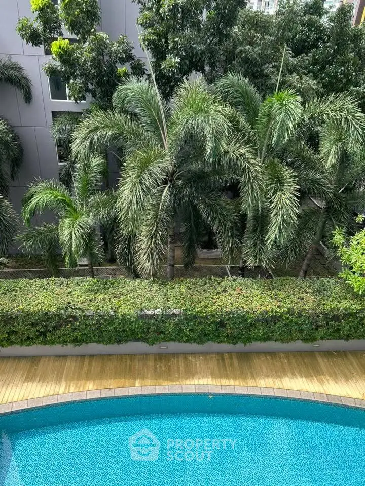 Luxurious poolside view with lush greenery and modern architecture.
