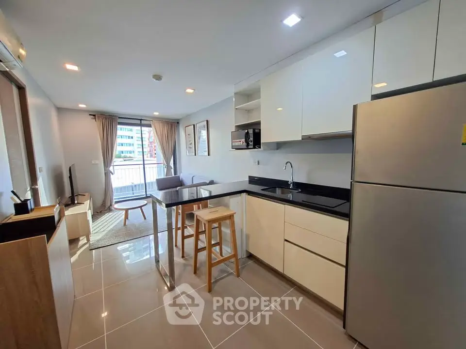 Modern open-layout kitchen and living room with sleek design and natural light.
