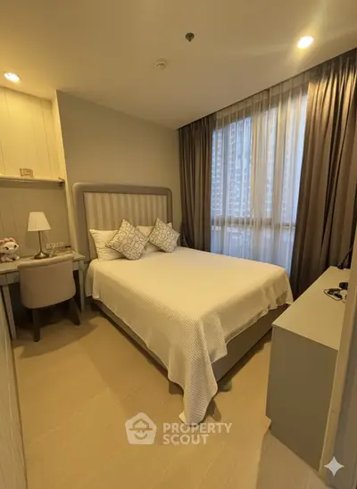 Cozy bedroom with modern decor and ample natural light in a stylish apartment.