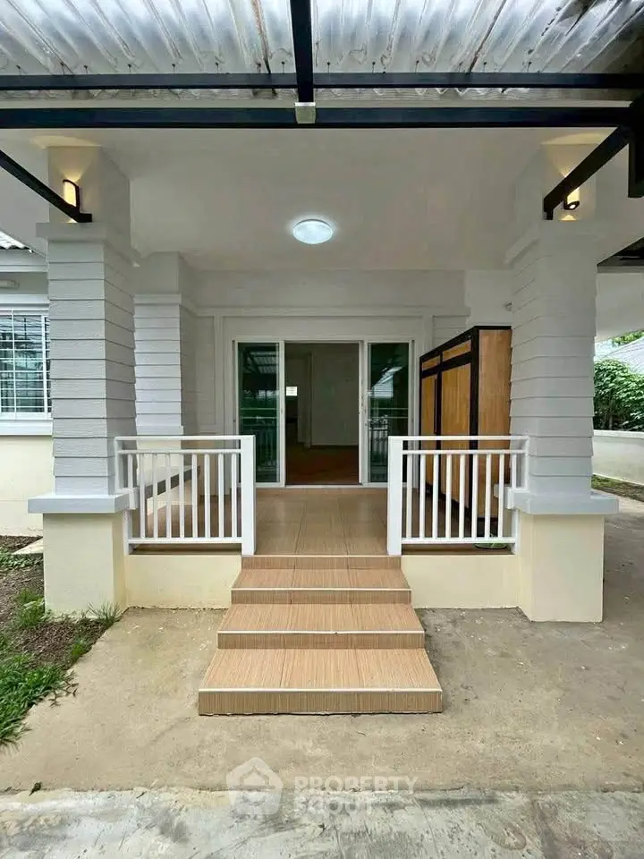 Charming single-story home entrance with modern design and inviting steps leading to a cozy interior.