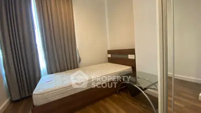 Cozy bedroom with single bed and modern glass side table, perfect for minimalist living.