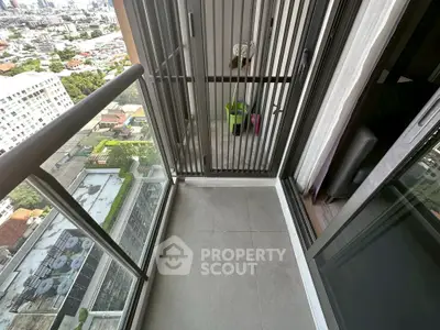 Modern high-rise balcony with glass railing and city view