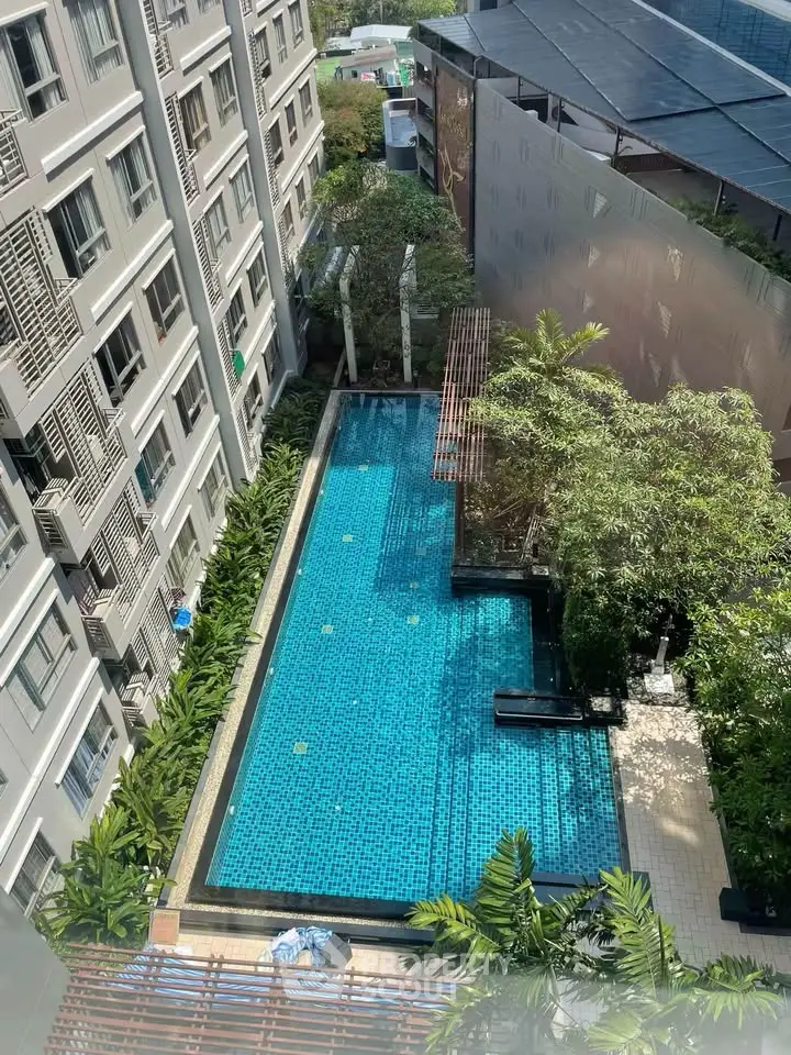 Stunning aerial view of modern apartment complex with inviting outdoor swimming pool and lush greenery.