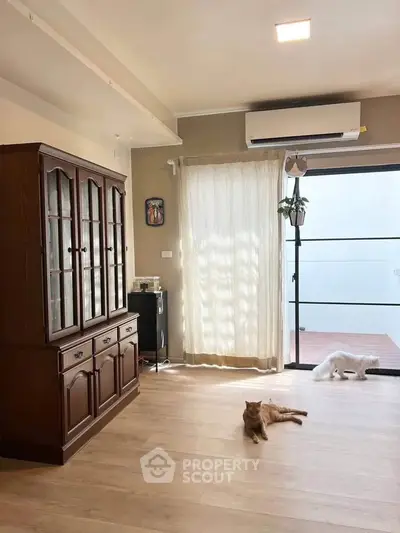 Spacious living room with wooden cabinet and large window for natural light