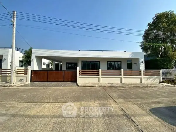 Modern single-story house with spacious driveway and minimalist design.