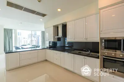 Luxurious modern kitchen with sleek white cabinetry and city view, perfect for culinary enthusiasts.