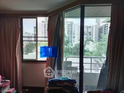 Spacious apartment with large windows and balcony offering city views.