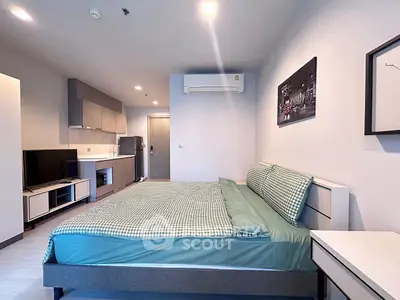 Modern studio apartment with sleek kitchen and cozy bedroom area, perfect for urban living.