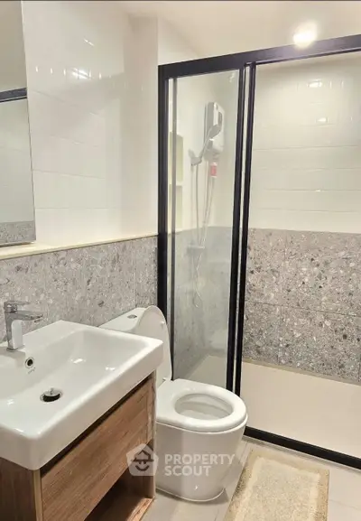 Modern bathroom with sleek design featuring a glass shower enclosure and contemporary fixtures.