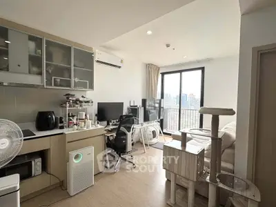 Modern living room with balcony view, featuring cozy furniture and home office setup.