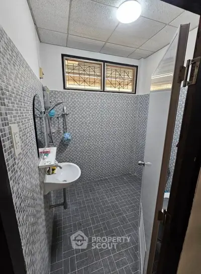 Modern bathroom with stylish gray tile design and sleek fixtures, perfect for a contemporary home.