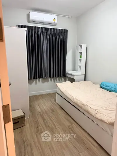 Cozy bedroom with modern furnishings and air conditioning, perfect for comfortable living.