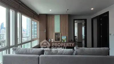 Modern living room with large windows and city view, featuring stylish decor and comfortable seating.