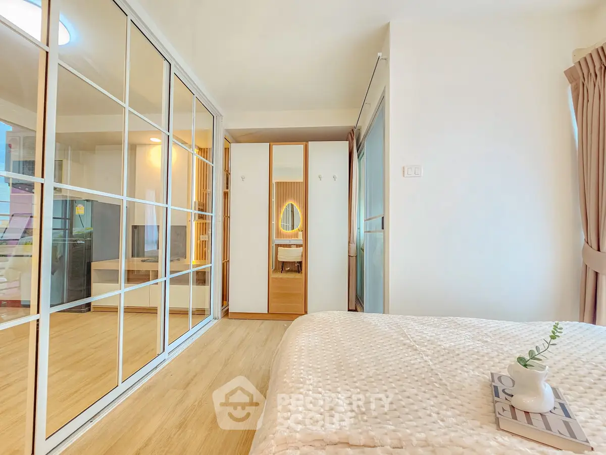 Spacious bedroom with elegant decor and ample natural light, featuring a cozy bed and stylish wardrobe.