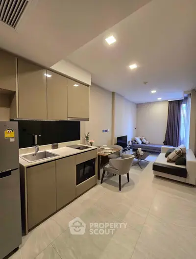 Modern open-layout kitchen and living room with sleek design and cozy seating area.