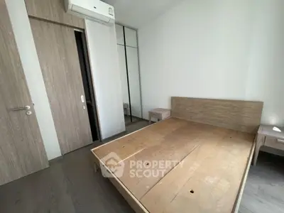 Modern minimalist bedroom with wooden flooring and built-in wardrobe