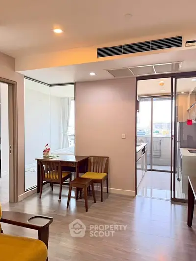 Modern apartment interior with open layout, featuring dining area and kitchen with sleek design.