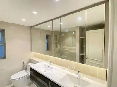 Luxurious modern bathroom with dual sinks and elegant mirror cabinetry.