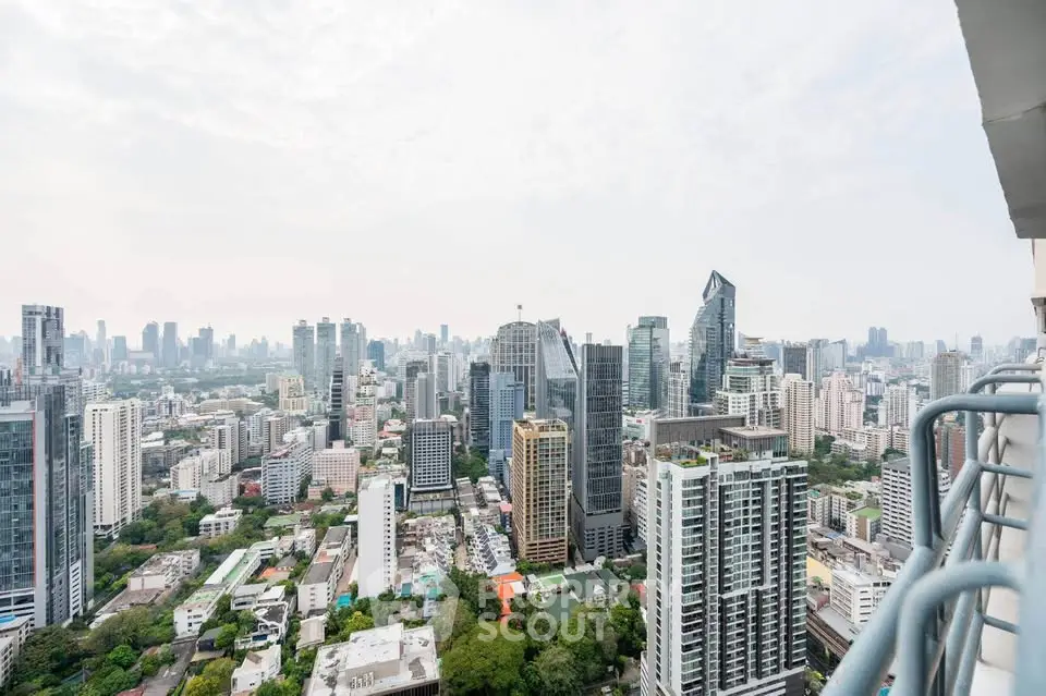 Stunning cityscape view from high-rise balcony showcasing urban skyline and lush greenery.