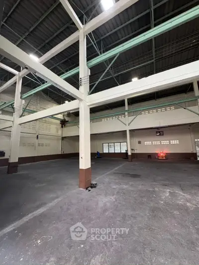 Spacious industrial warehouse with high ceilings and ample natural light.